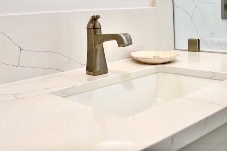 seamless backsplash vanity with gold faucet